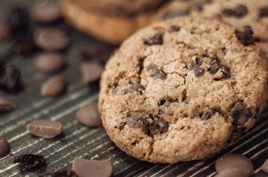 Homemade chocolate chip cookie on dark wooden board