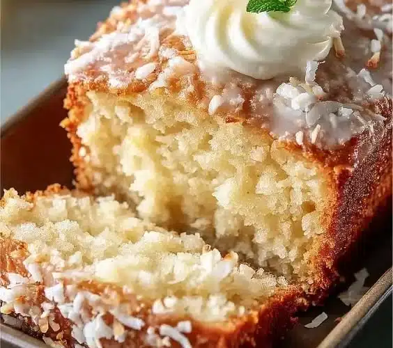 Delicious coconut loaf cake topped with fresh coconut flakes
