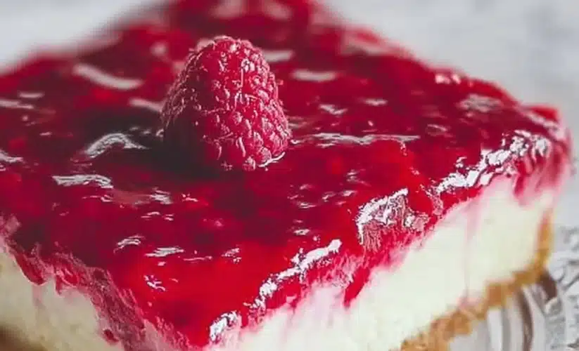 Slice of dreamy raspberry cheesecake topped with fresh raspberries